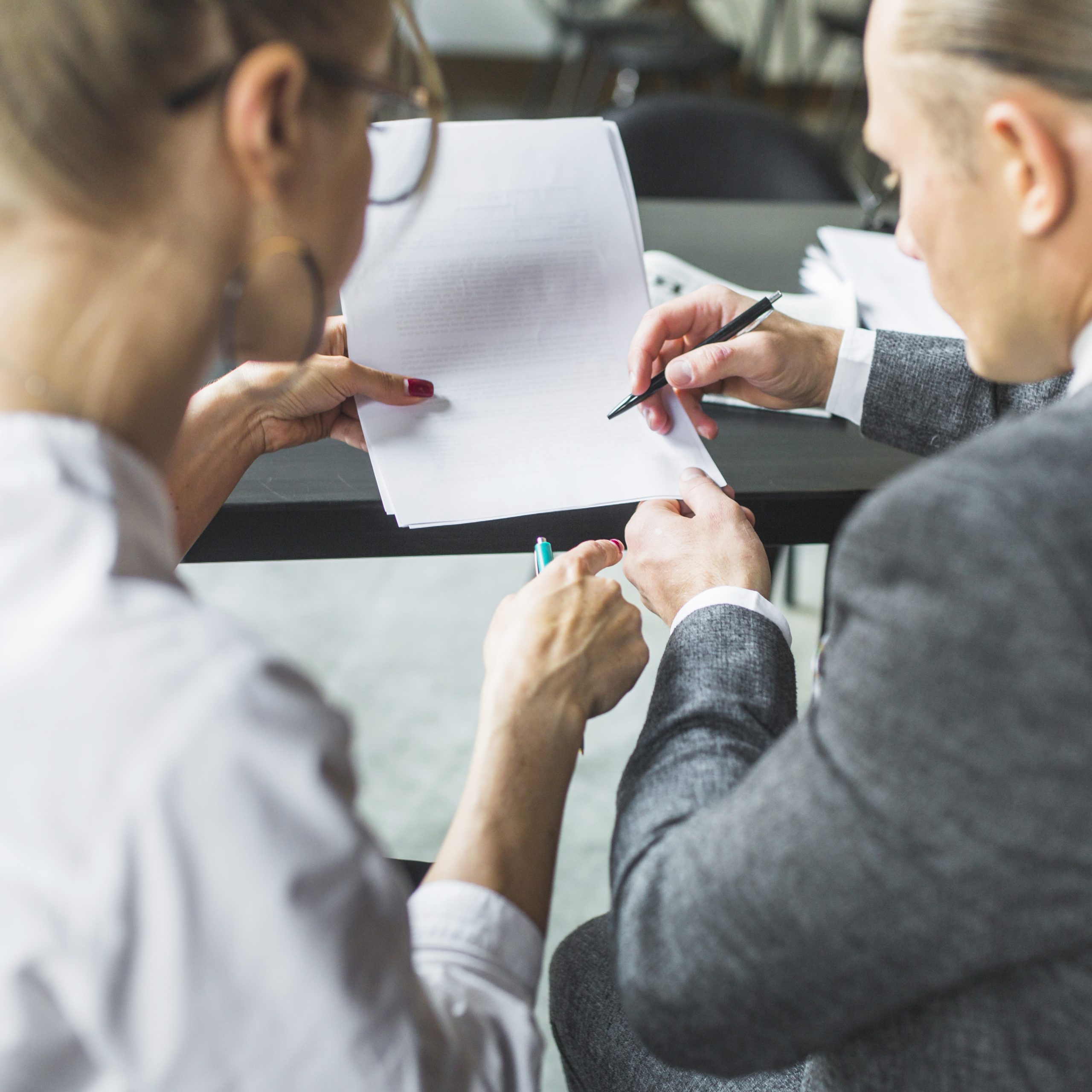 close-up-two-businesspeople-checking-document-restaurant